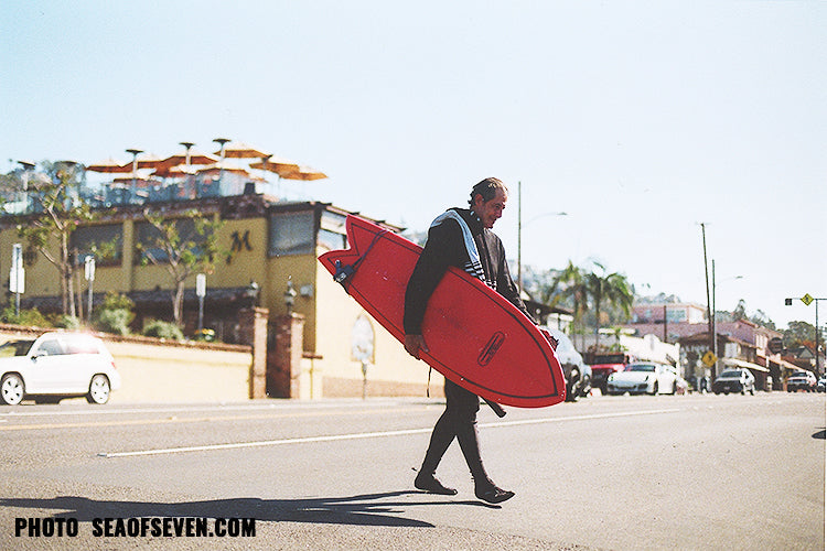 surfer crossing the street laguna beach pch