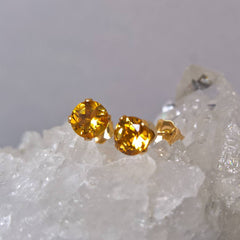 Close up of Citrine stud earrings on a crystal