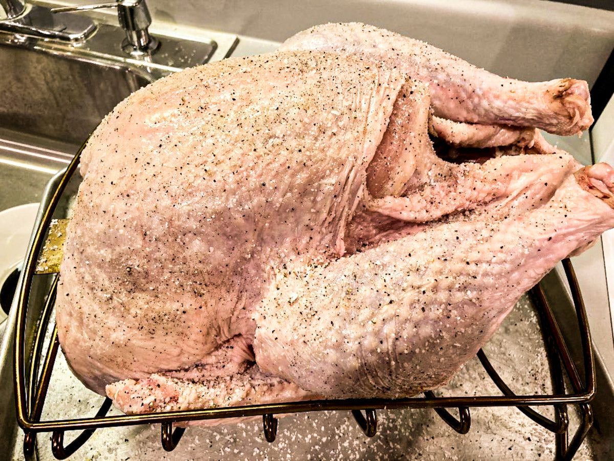 Photo of raw turkey dry rubbed with salt and pepper