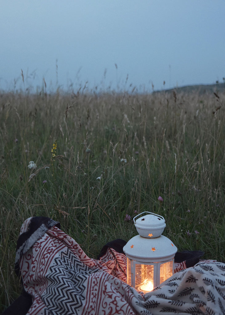 Summer picnic on the South Downs at dusk with lit lantern by Lewes Map Store