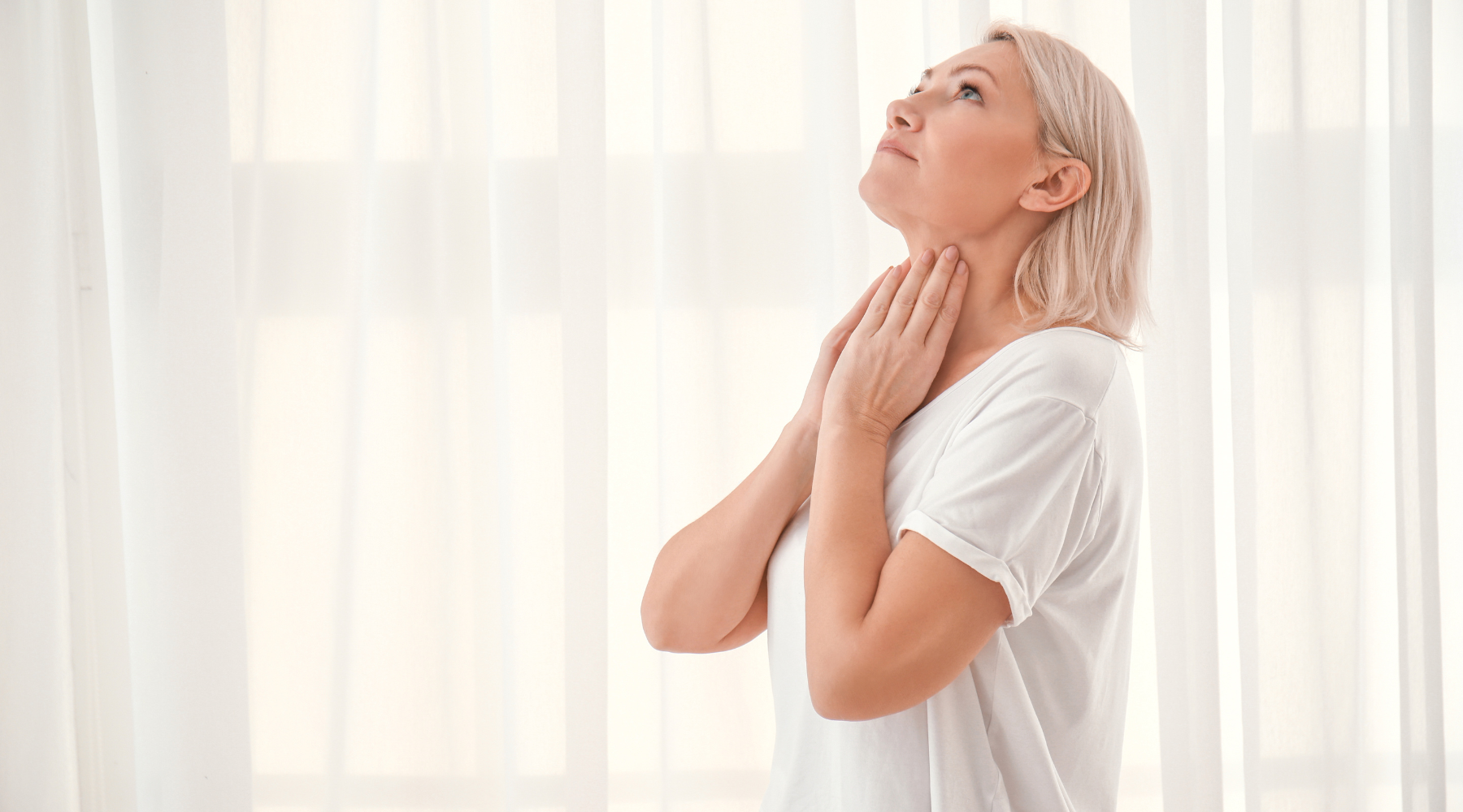Woman holding neck - thyroid health