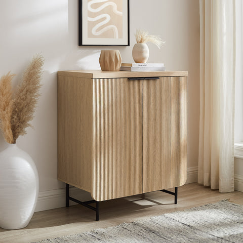 Fluted door accent cabinet with minimal hardware in an entryway with neutral decor.