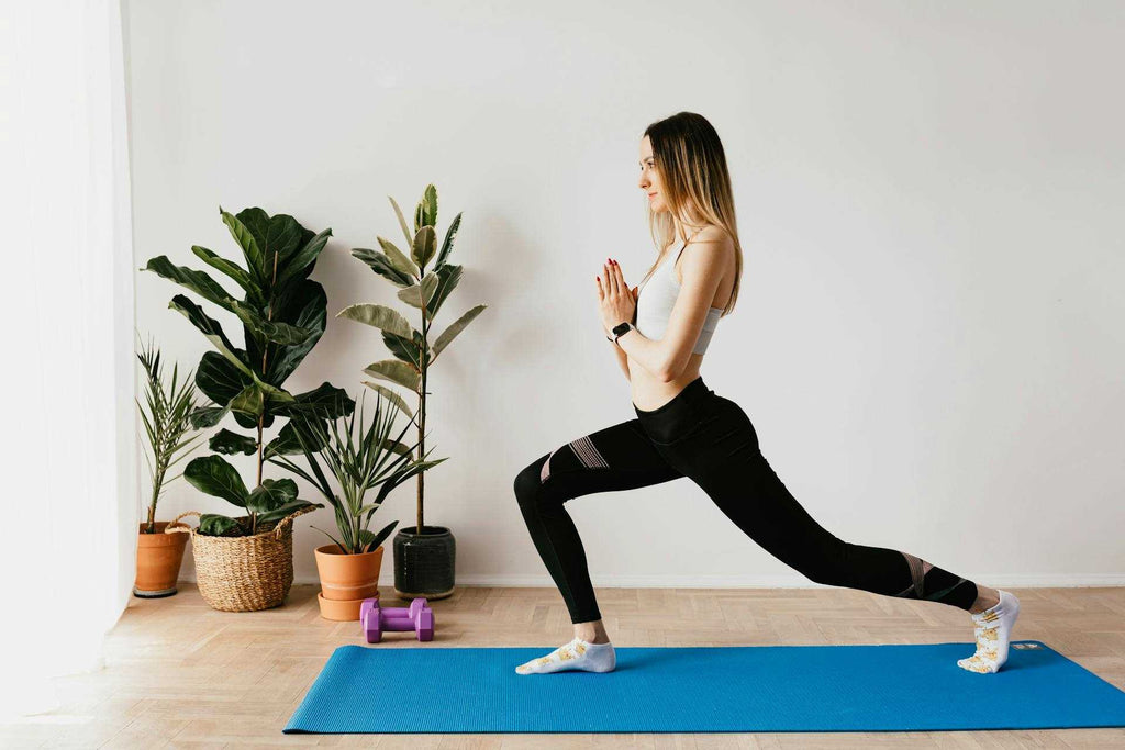 a woman doing a yoga pose on a blue yoga mat