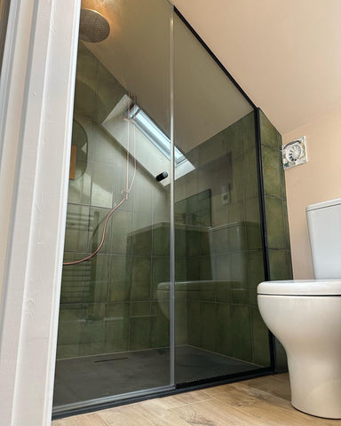 Sloped ceiling shower enclosure with matte black shower components