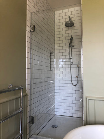 Large frameless shower door with Chrome fixtures and fittings