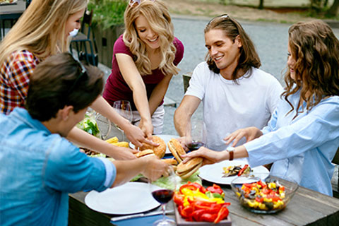 A happy group of people is sharing food at the table 