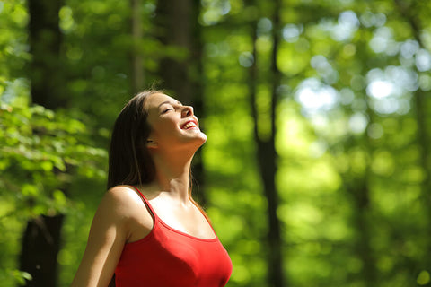 A happy teenage girl enjoying the sunlight and fresh air brought by nature