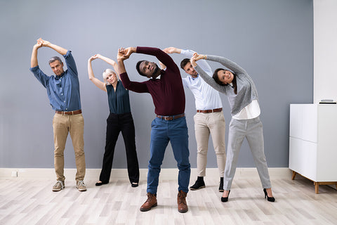 Employees doing fitness routine exercises at their workplace