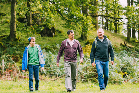 Three men of different generations walking in the woods happily