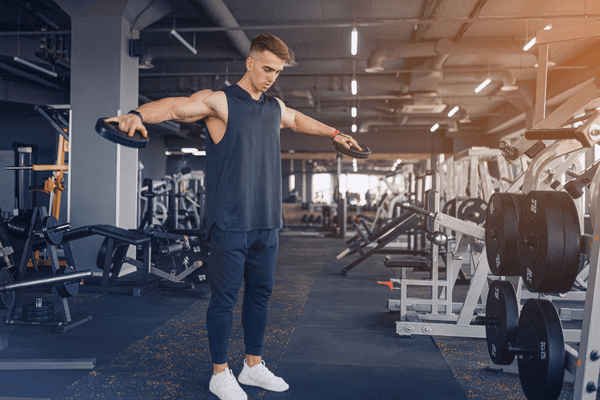 A Man Lifting A Two Weights In His Hand Doing Lateral Raise