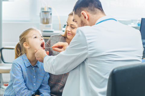 A girl is accompanied by her mother while having a visit to her dentist