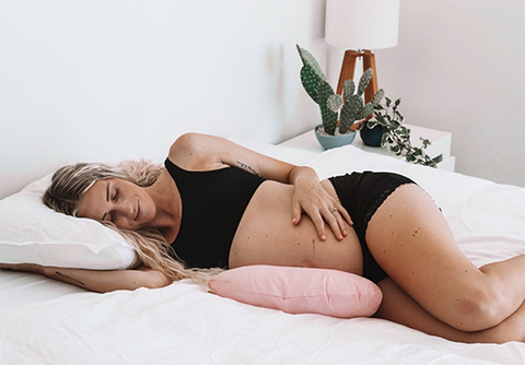 Pregnant woman lying on Butterfly Maternity Pillow in bed