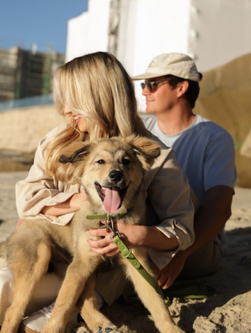 Cymbiotika couple with pet on beach