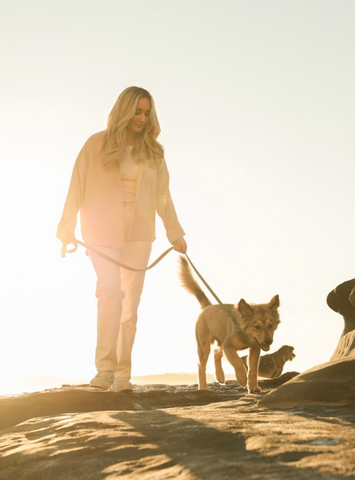 Cymbiotika customers with pet walking along the sunset