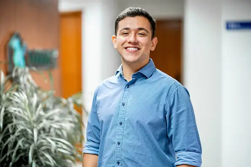 smiling-young-businessman-standing-in-the-corridor-of-an-office__PID:a4ad9d5a-828a-44dc-b9fc-c7173fee01a2