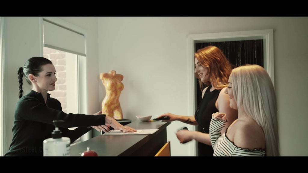 Two women being shown some paperwork in front of a receptionist