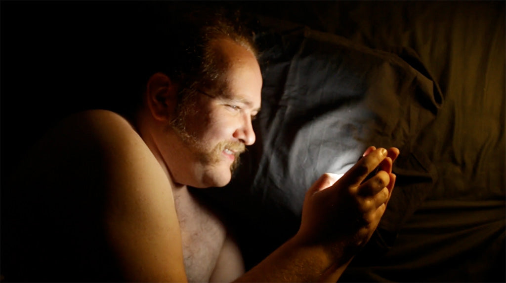 man in bed looking at his phone