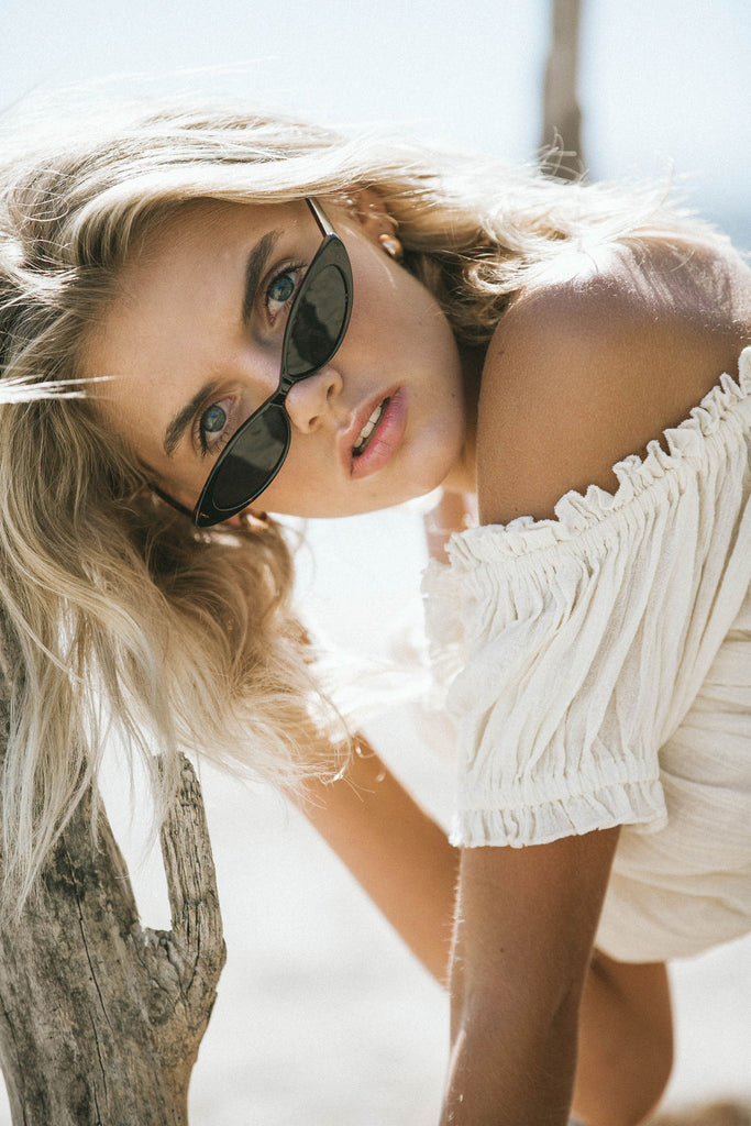 Our model Bronte wearing cream off-shoulder blouse and black sunglasses