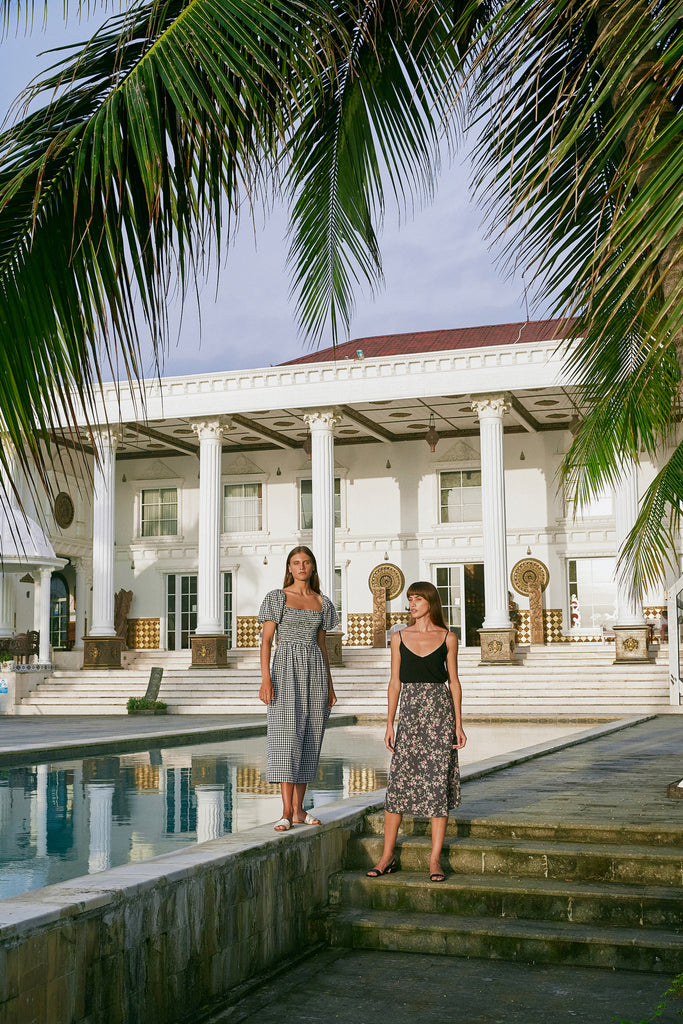 Two women wearing Hazel & Folk dresses standing next to a pool of a house