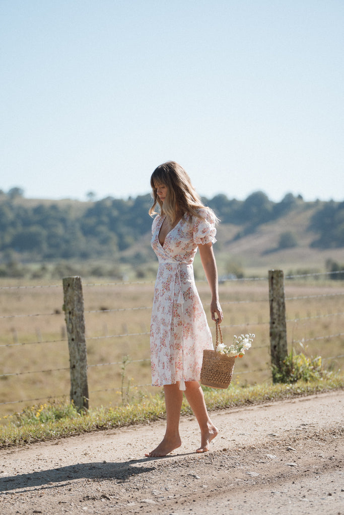 women on a dirt country road wearing a floral summer dress