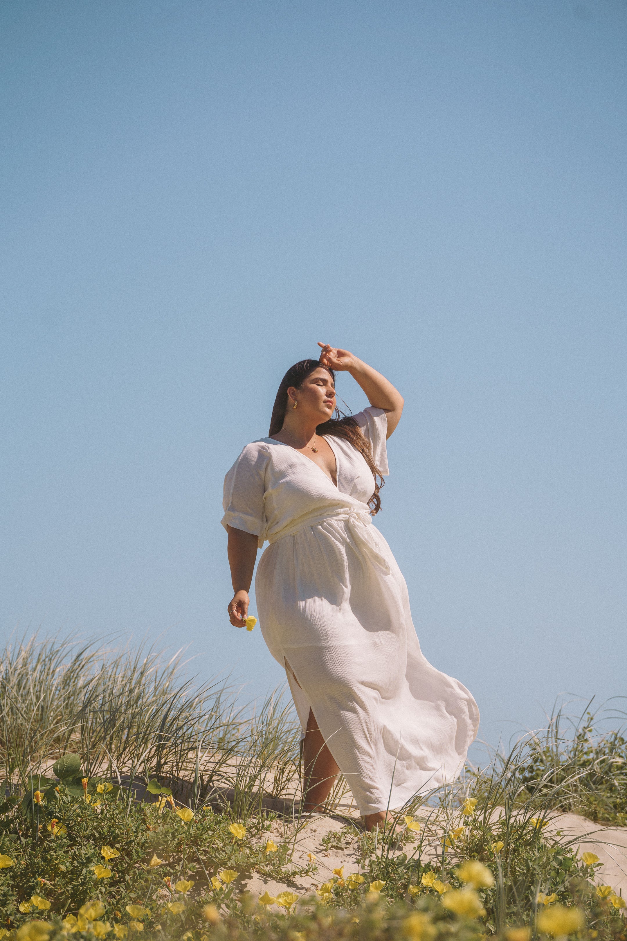 Plus size woman wearing wrap white maxi dress