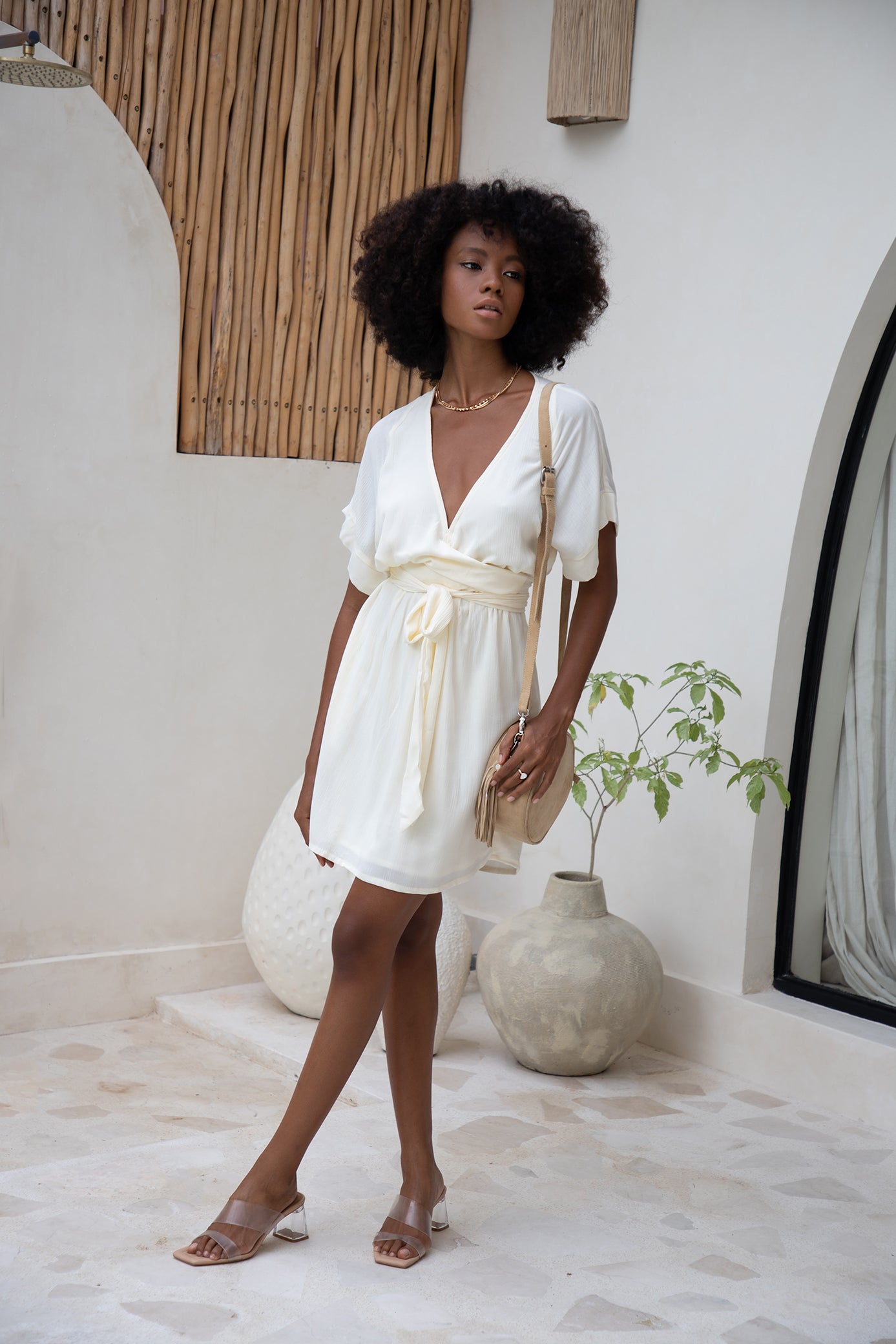 Woman wearing mini white wrap dress