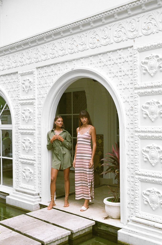 Two women wearing Hazel & Folk dresses standing in a doorway of a house