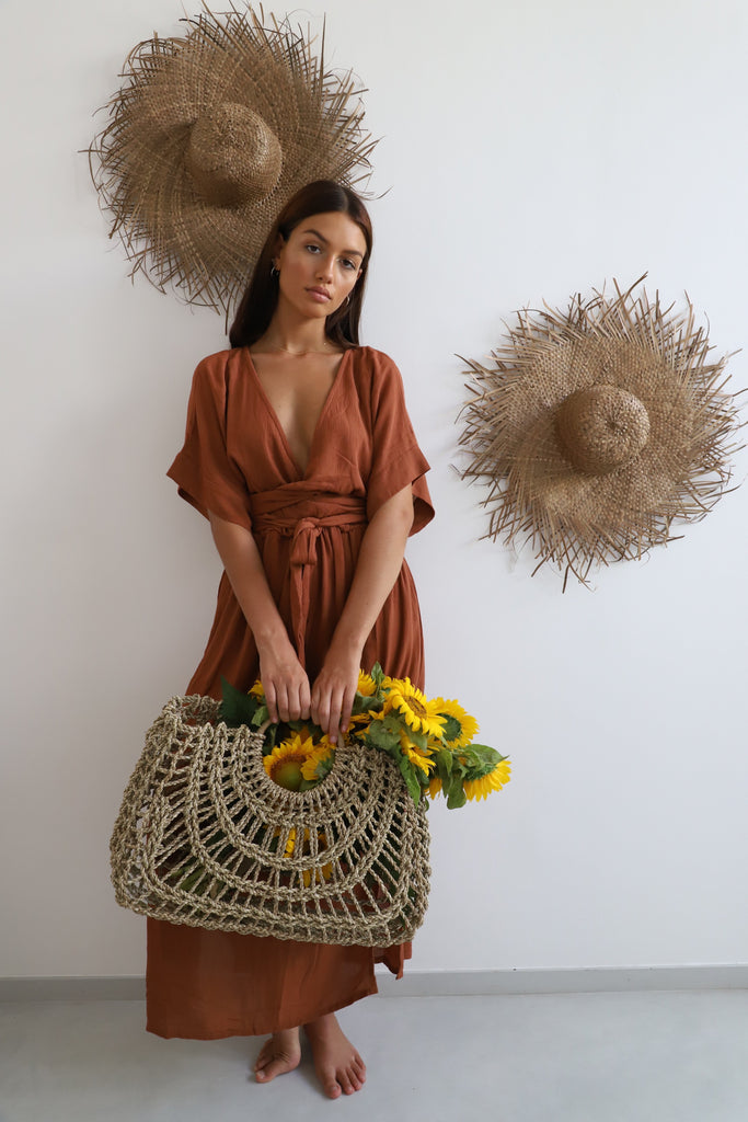 dark haired woman wearing rust coloured Hazel & Folk dress 