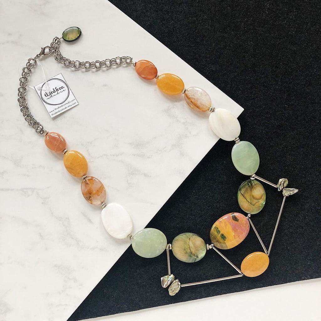 Semiprecious stone statement necklace handmade in Michigan by Third & Co. Studio with orange peach and mauve Citrine, green and brown Mother of Pearl, Mookaite Jasper in green yellow and purple, white Jade, and light green Prehnite with chunky silver chain