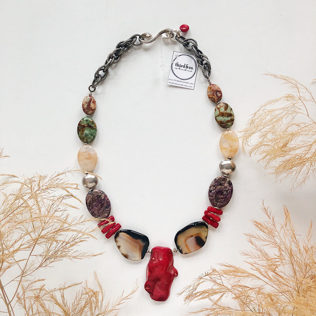 Semiprecious stone statement necklace from Third & Co. Studio handmade in Michigan with red coral, Black and Tan Agate, orange Citrine, purple and black Chariote, and chunky silver chain adjustable length