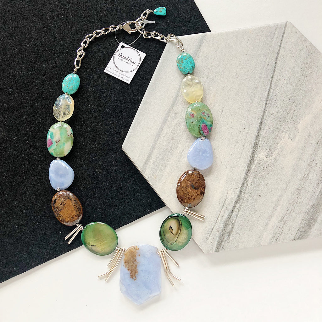 Semiprecious stone statement necklace by Third & Co. Studio handmade in Michigan with blue Chalcedony, Sterling Silver spikes, green and brown Mother of Pearl, brown Jasper, green and pink Ruby in Fuchsite. blue green Turquoise and yellow Pineapple Quartz with silver chain adjustable length