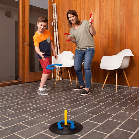 Mother playing horseshoes indoors with child