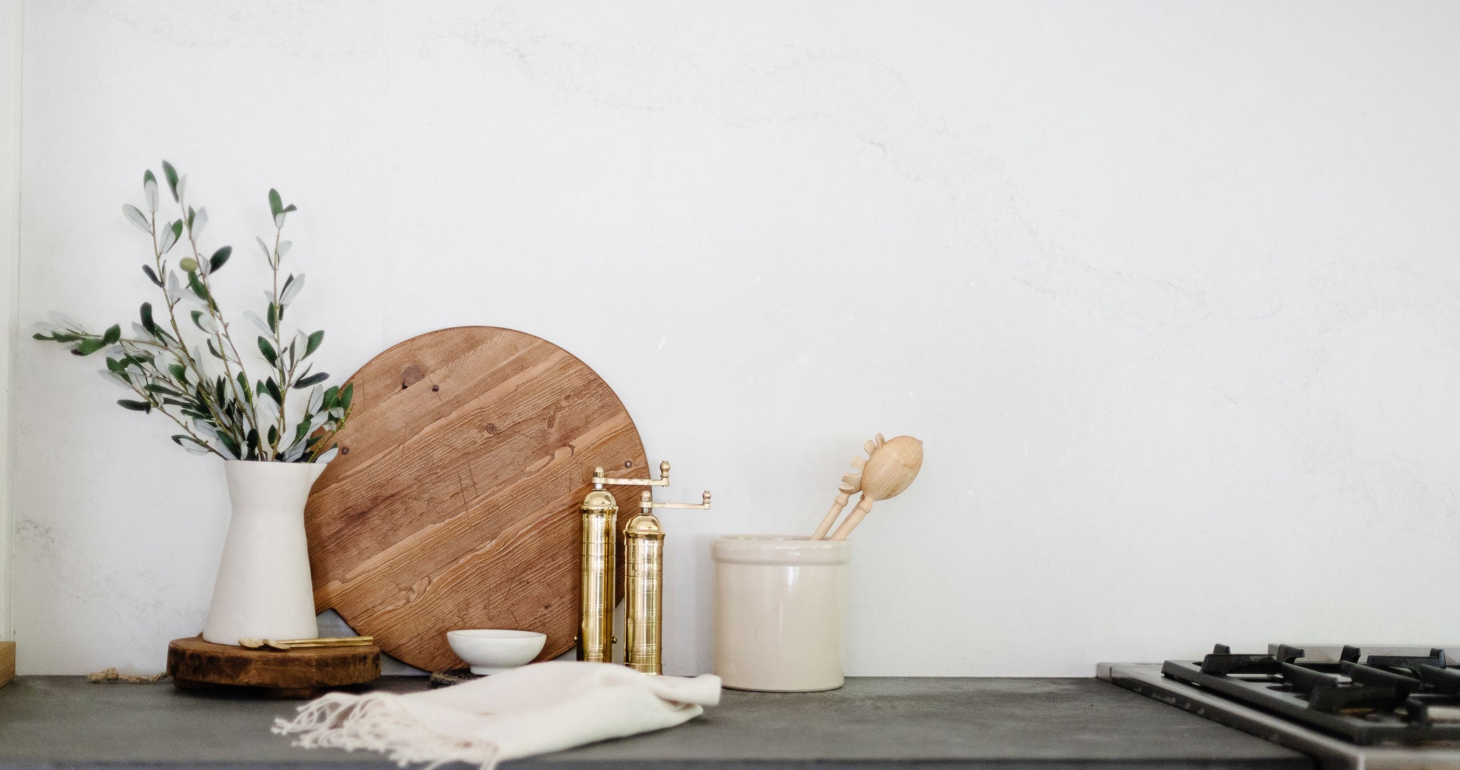 Stack of linen cotton kitchen towels, handmade wooden spoons, on white kitchen  table, Provence style, interior design Stock Photo