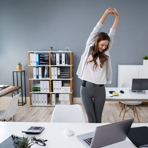 A woman stretching at her desk