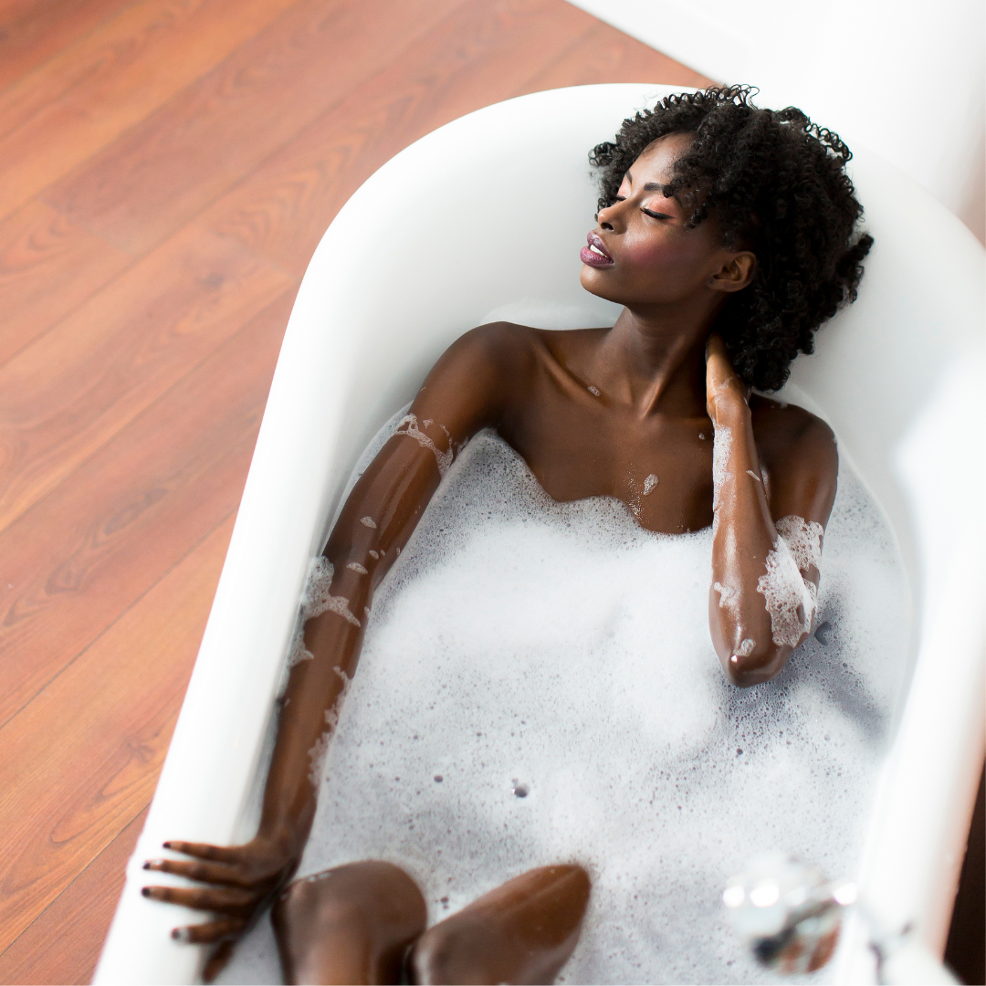 a woman relaxing in an epsom salt bath to release tension