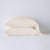 Madera Luxe Pillowcase (Single) - Renewal | Parchment | sleeping pillows stacked neatly against a white backdrop - side view.