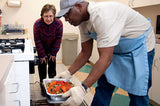 Image of a blind man putting a casserole in the oven 