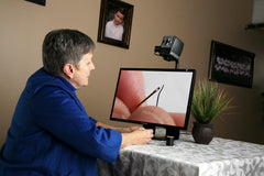 Image of a woman using an Acrobat CCTV to help thread a needle
