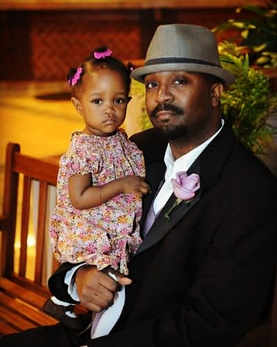 african american father and daughter malaya and jason austin sitting posing for a picture. 