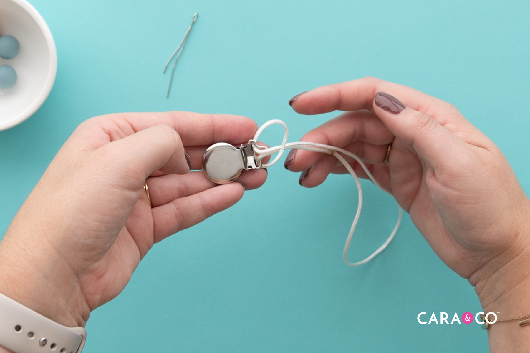 Loop your cord through the Clip - Pacifier Tutorial - Cara & Co