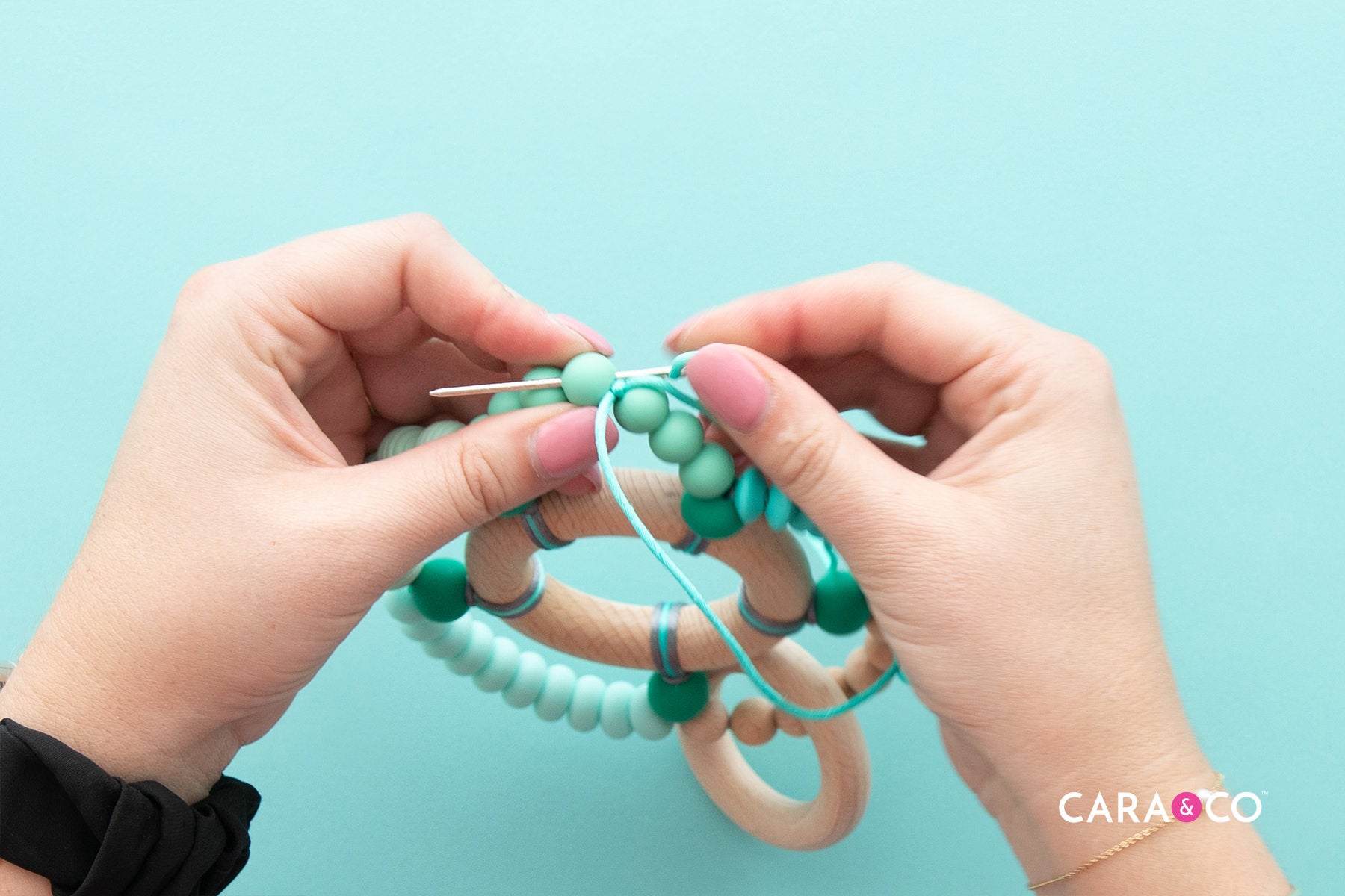 Pull your knot into the next bead - Teething Ring Tutorial - Cara & Co