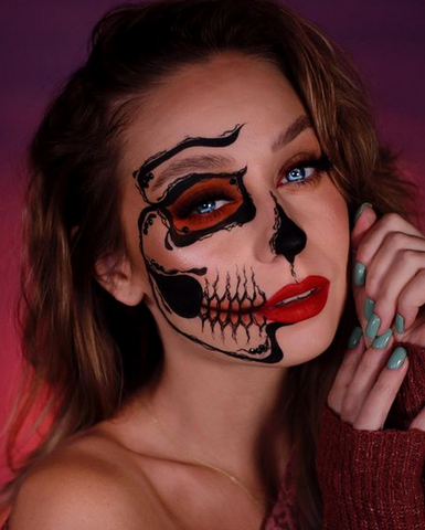 model with half of her face done with skull makeup and the other half normal makeup