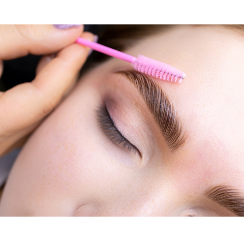 model brushing brows with spoolie brush