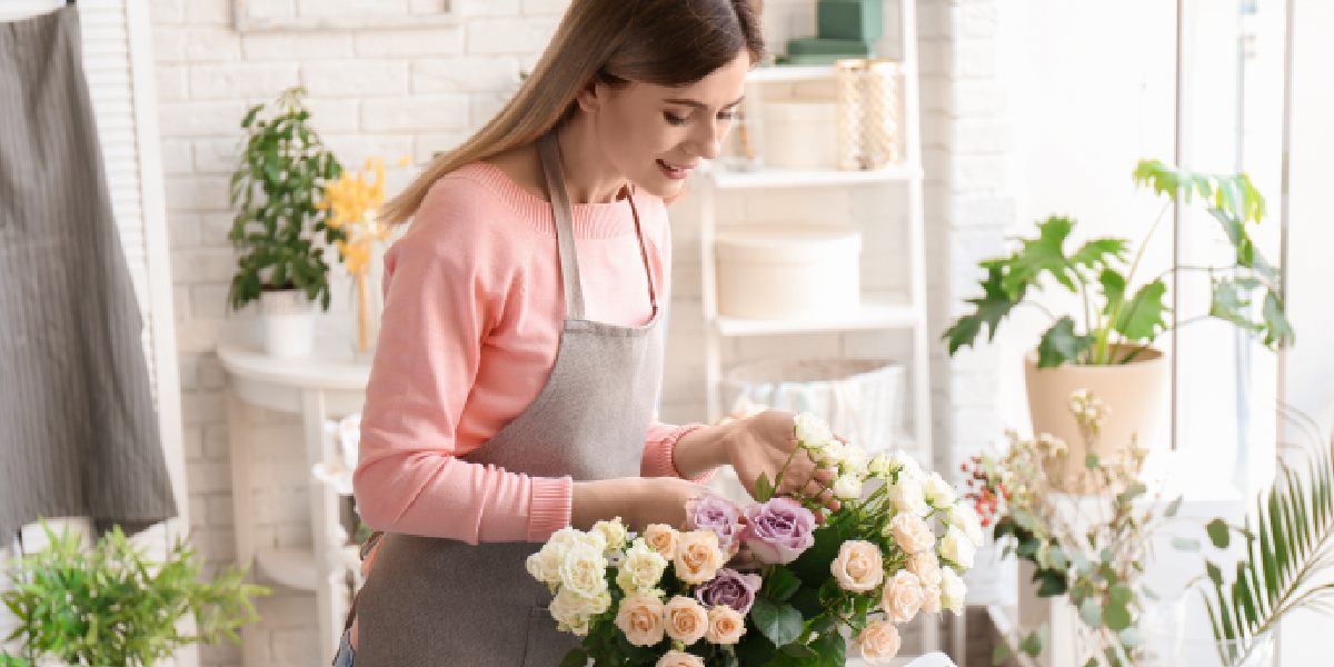 Ladty arranging artificial flowers indoors