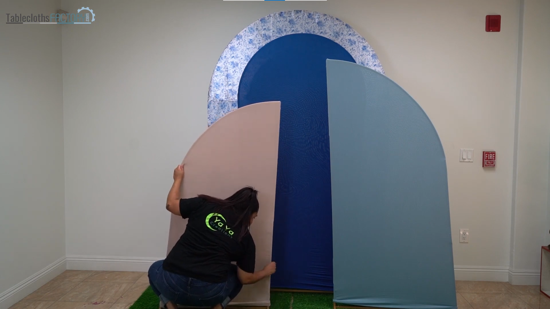Person assembling the backdrop stands with fitted covers