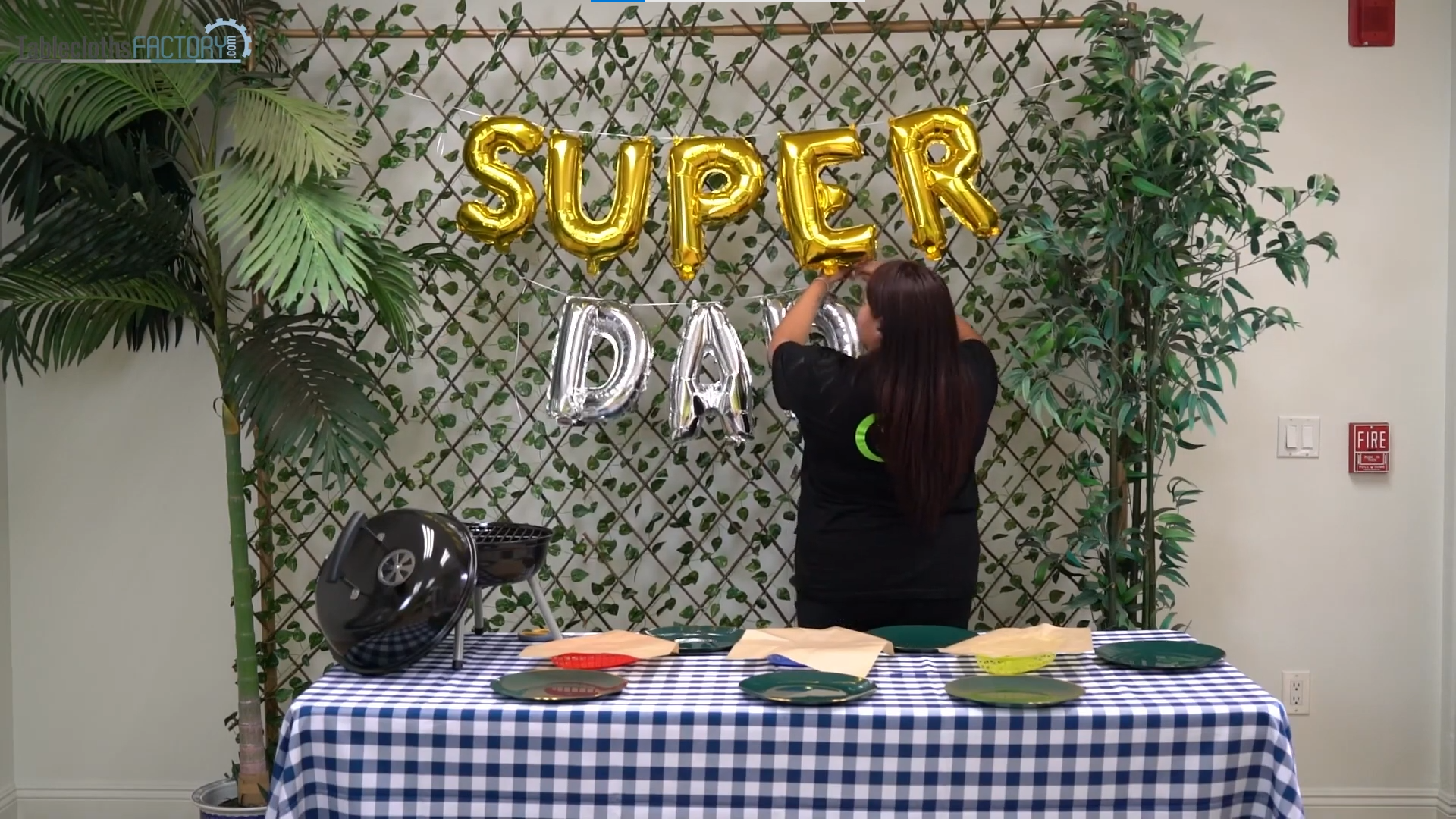Woman hanging letter mylar foil balloons against the backdrop