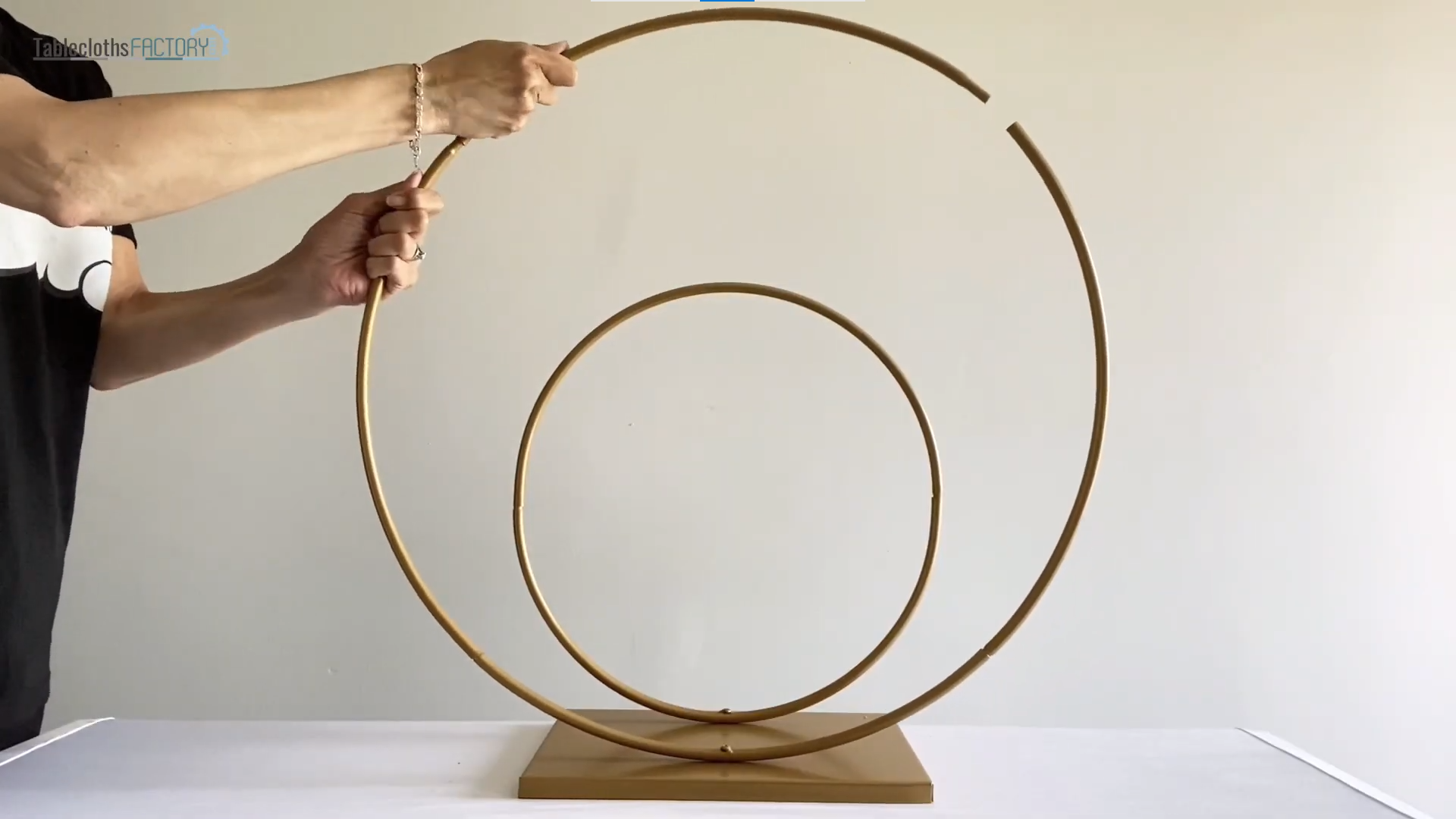 Person assembling a double hoop metal stand
