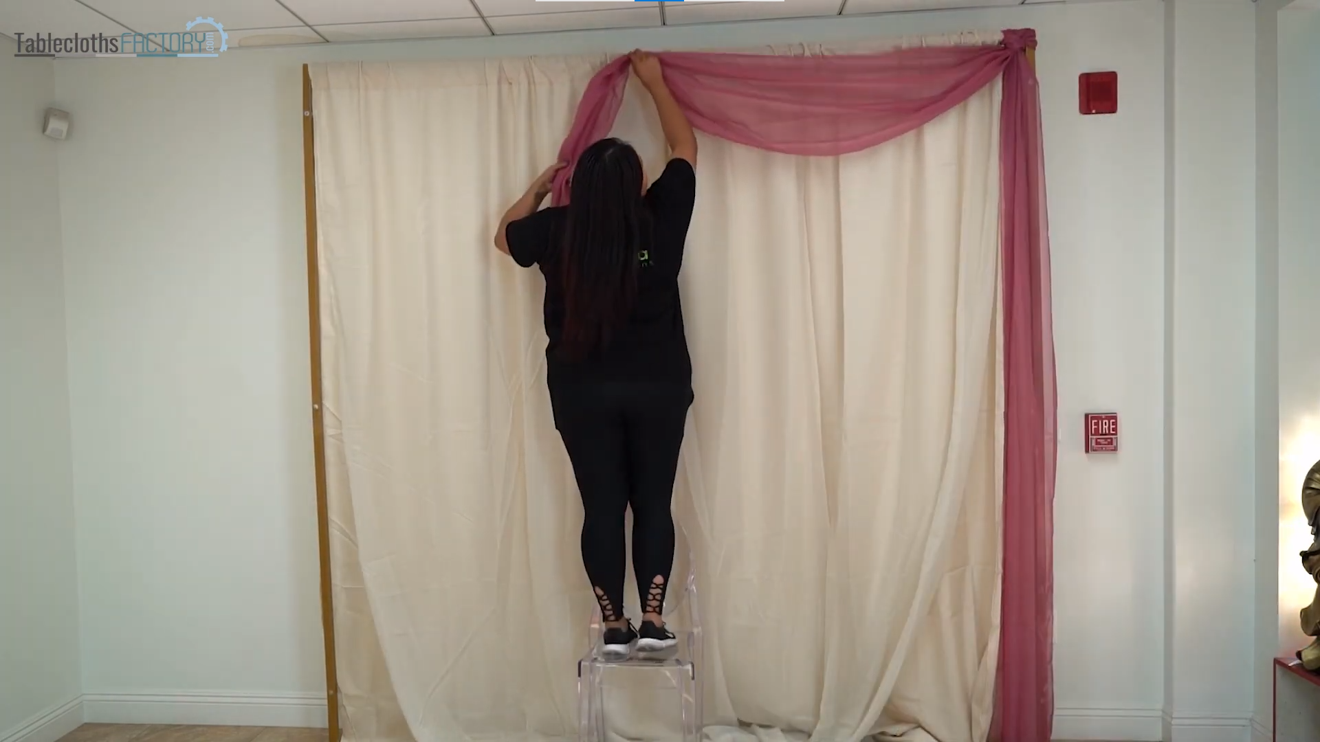 Person assembling the backdrop stand and drape curtains
