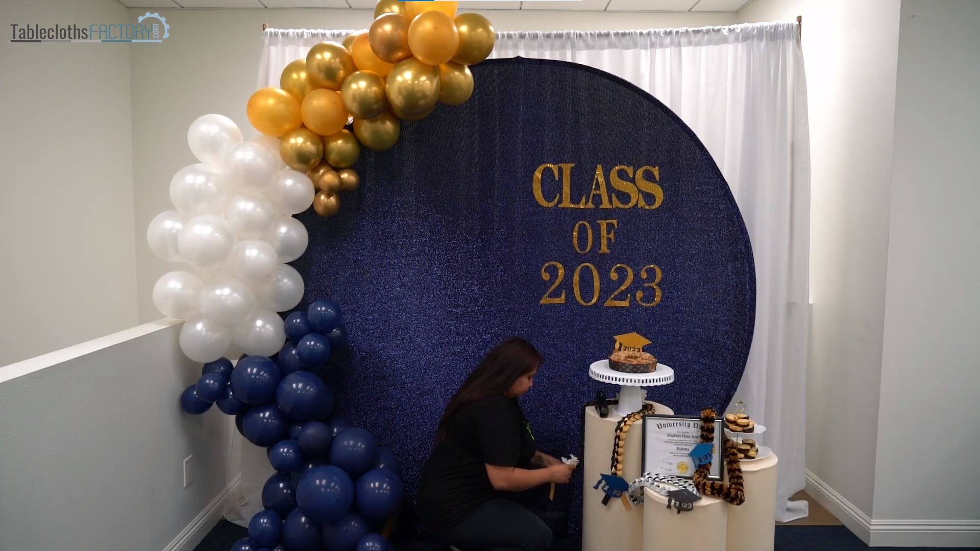 Woman decorating the acrylic stands with treats and graduation decor