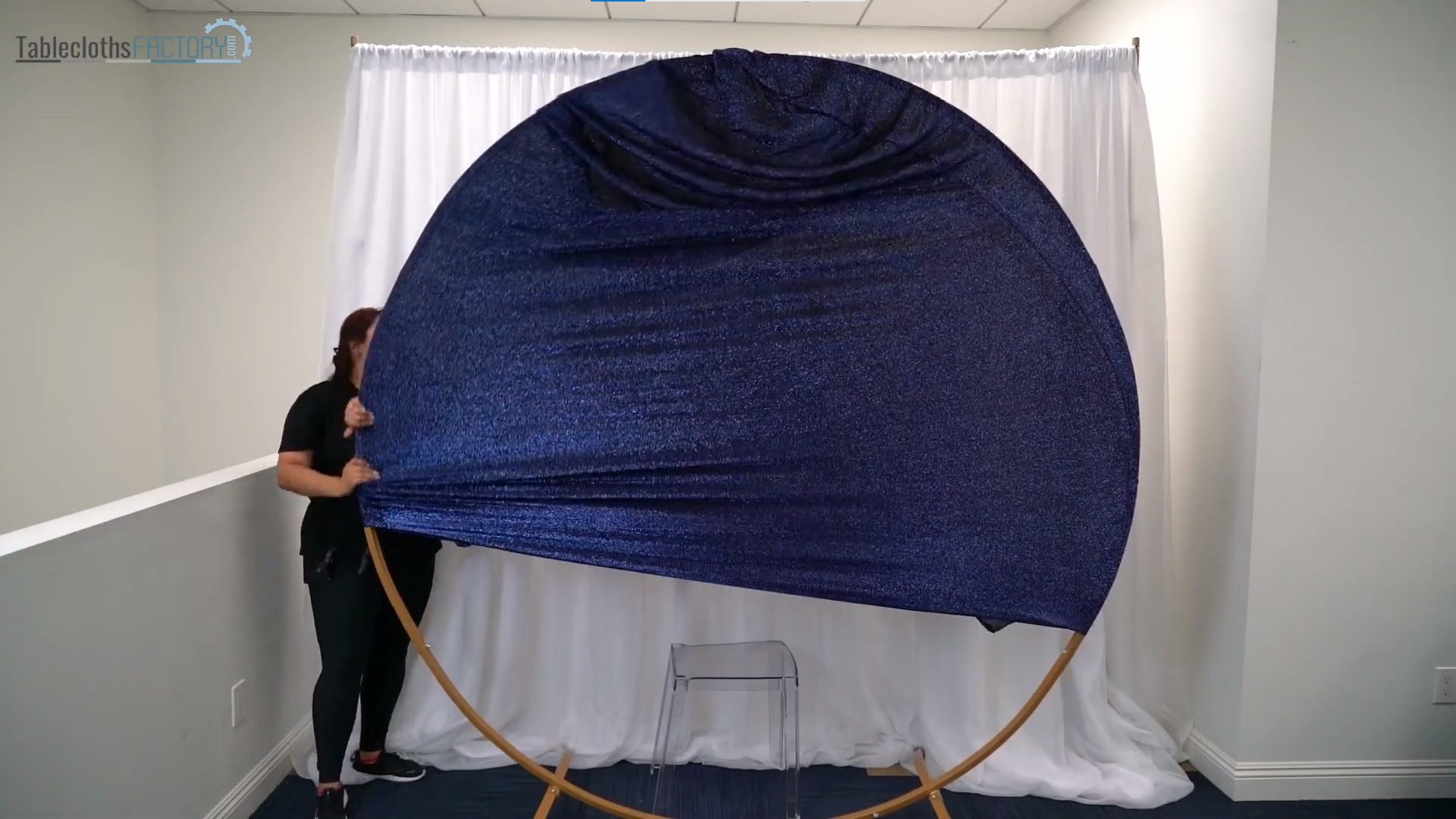 Woman assembling a metal arch and putting a fitted royal blue spandex shimmer cover